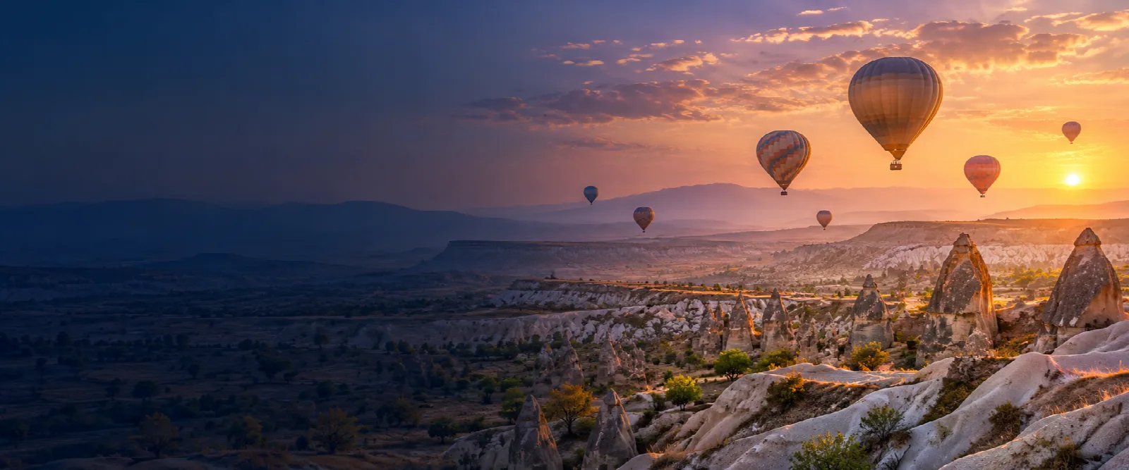 Cappadocia valleys and hot air balloons at sunrise