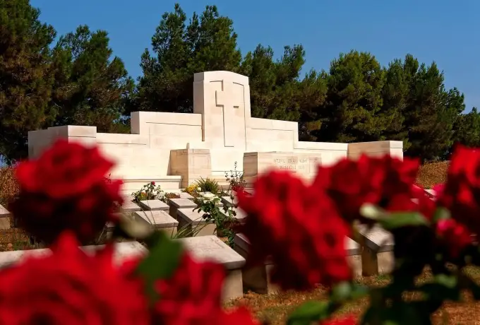 Red roses planted in front of a memorial stone at a Gallipoli cemetery.
