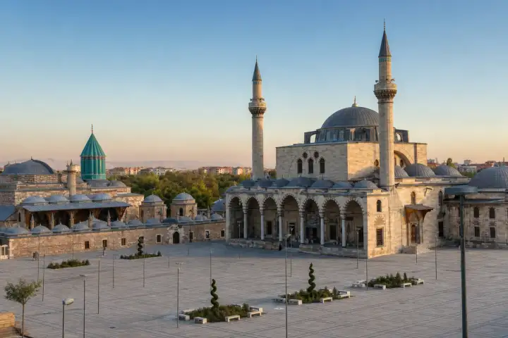 The turquoise dome of the Mevlana Museum beside Selimiye Mosque in Konya at sunrise.