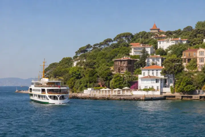 A passenger ferry approaching the wooden waterfront mansions of Büyükada in the Princes Islands.