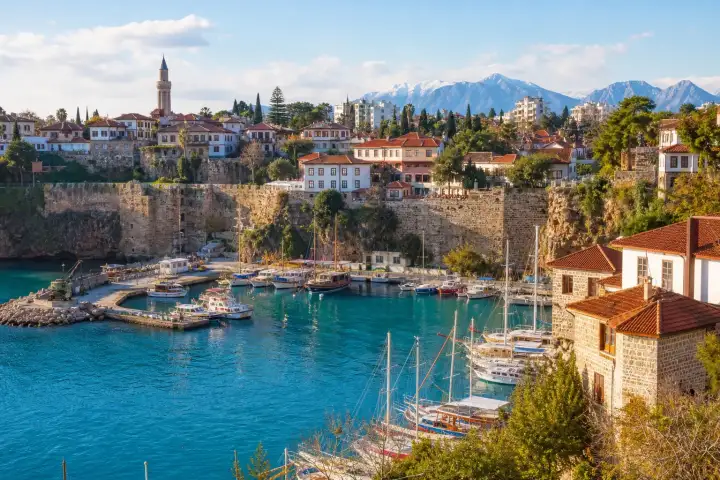 Antalya Kaleiçi marina beneath the historic city walls with the Taurus Mountains beyond.