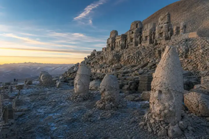 Colossal Commagene statues and weathered stone heads on the eastern terrace of Mount Nemrut.