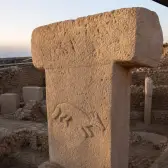 An animal relief carved into a weathered T-shaped pillar within the Göbeklitepe enclosure.