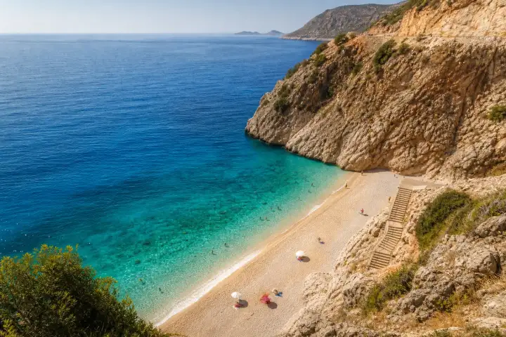 The turquoise Mediterranean waters and steep limestone cliffs of Kaputaş Beach on the Antalya coast.