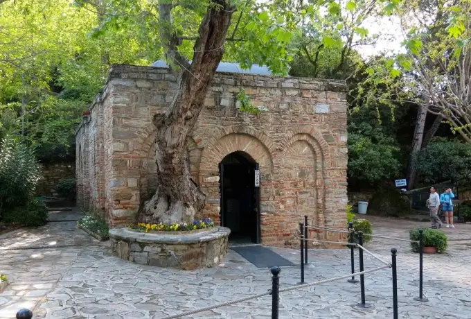 A gnarled old tree grows against the wall of the small stone chapel at the House of the Virgin Mary above Selcuk.