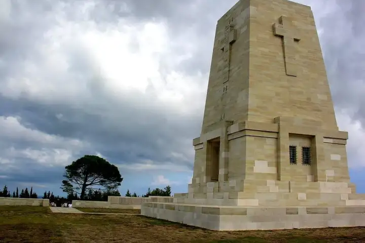The tall carved memorial at Lone Pine cemetery stands against a heavy grey sky on the Gallipoli peninsula.
