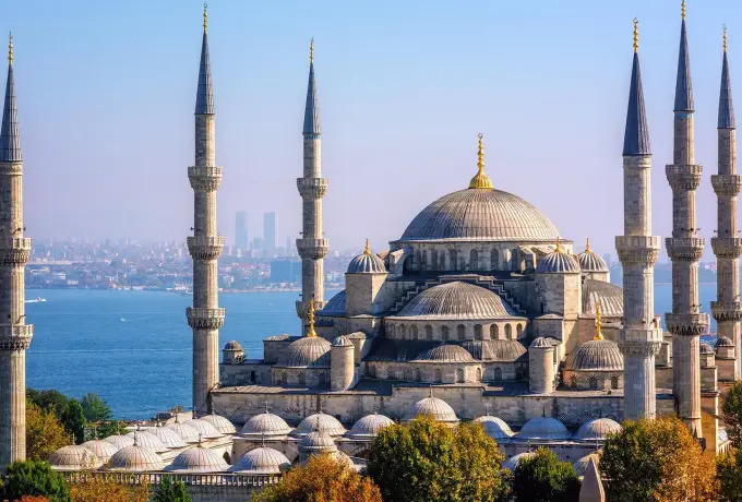 All six minarets of the Blue Mosque frame its cascading domes in Istanbul with the Bosphorus and the Asian shore behind.