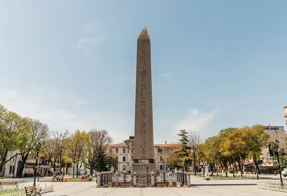 The Obelisk of Theodosius stands on its carved base in the old Hippodrome square in Istanbul, hieroglyphs clear on its faces.