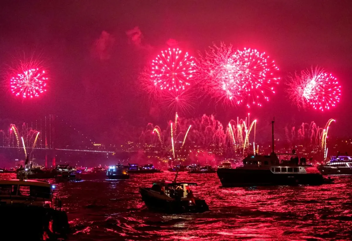 Pink fireworks fill the sky over the Bosphorus in Istanbul as crowded boats watch the display from the water.