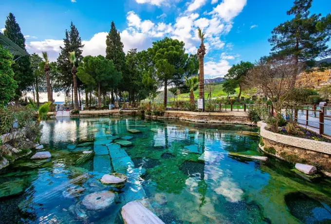 Sunken Roman column sections lie clearly visible through the turquoise water of the Cleopatra pool at Pamukkale.