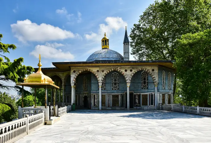 A domed Ottoman kiosk with a tiled portico stands in the terraced gardens of Topkapi Palace in Istanbul.