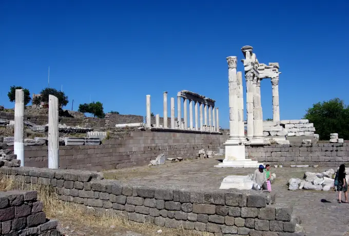 Standing columns and a broken pediment of the Pergamon temple terrace stand out against a deep blue sky.