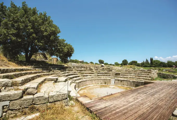 Curved stone seating survives at the small theatre of ancient Troy, a wooden boardwalk crossing the orchestra below.