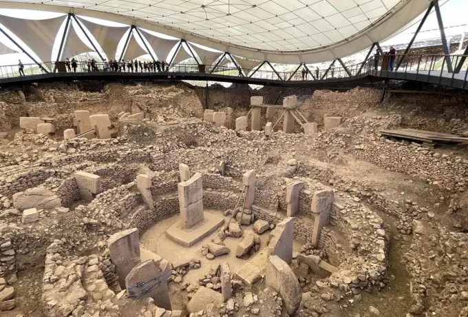 The main circular enclosure at Gobeklitepe lies open under the site canopy, its T-shaped pillars standing among stone walls.