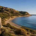 The peaceful shoreline and steep ridges of Anzac Cove on the Gallipoli Peninsula